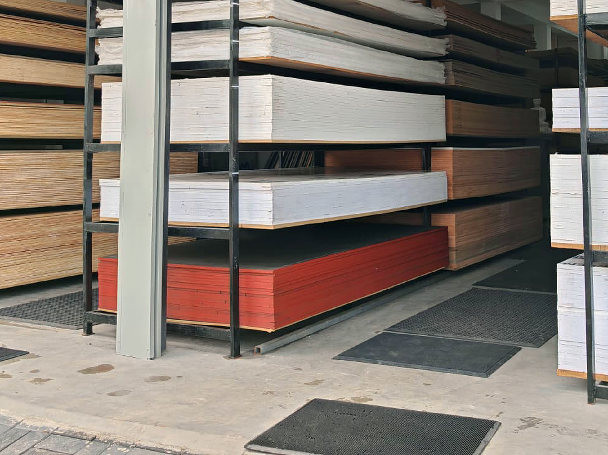 Red faced sheets under white boards on the kerbside rack at the front of the store.